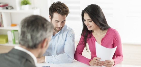 Image d'un couple se faisant conseiller par un professionel dans un bureau