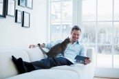 Homme dans son canapé avec sa tablette et son chat